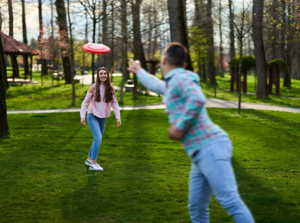 istock Young couple playing freesbie in the park 1316111435