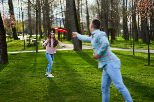 istock Young couple playing freesbie in the park 1316111462