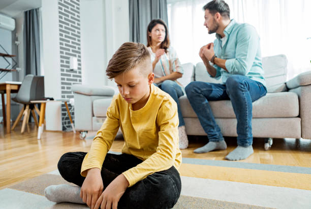 Sad little kid boy with mother and father fighting Little kid boy with mother and father fighting arguing couple divorce family stock pictures, royalty-free photos & images