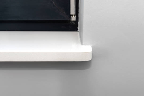 istock Newly installed white conglomerate window sill inside the room, on the gray wall. 1316112776