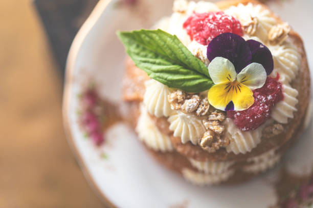 おいしいバタークリームケーキ と 食用パンジーフラワー - flower cake cookie food ストックフォトと画像