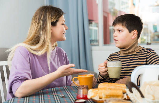 istock Young woman and son chatting at table with tea indoors 1316119005