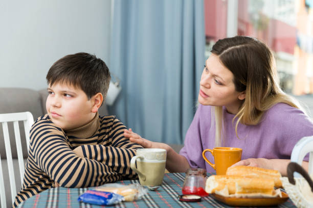 istock Sad son and unhappy mom having quarrel during breakfast indoors 1316119070