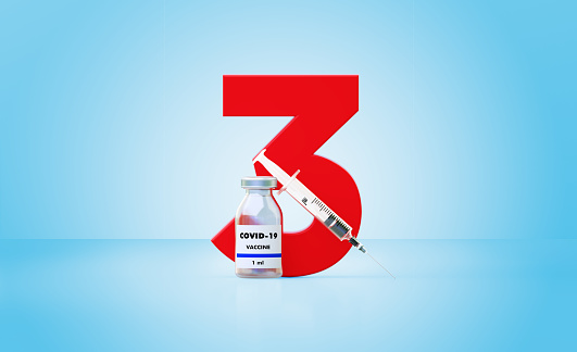 Botella de vacuna Syringe y COVID-19 sentada junto a un enorme número tres rojo sobre fondo azul photo
