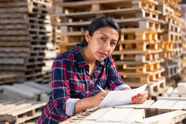istock Female worker checking quantity of red bricks in warehouse 1316121175