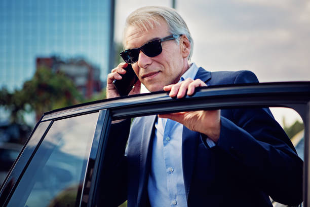 istock Businessman is talking and exiting/entering his car 1316122374