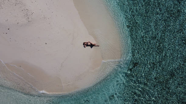 istock Mature lady on vacation laying on a tropical beach 1316124704