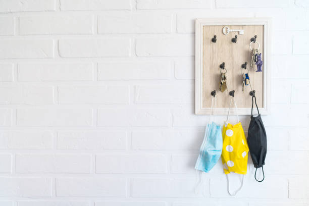 istock Tree protective face masks on the keys organizer hook on the loft design white background brick wall in the home hallway. Health care concept during COVID-19 pandemic concept background image. 1316127155