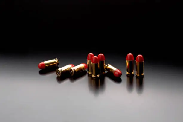 Photo of Bullet isolated on black background with reflexion. Pistol bullets close-up on black back. Cartridges for pistol on a black.