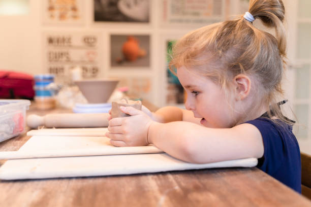 pretty little girl sculpting with clay on the pottery workshop. - sculpture clay human face human head imagens e fotografias de stock