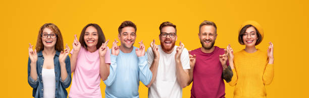 istock Happy young people making wishes with crossed fingers 1316130593