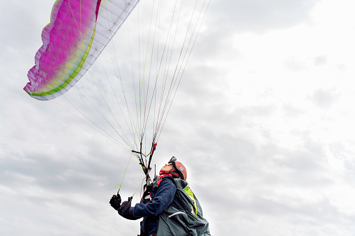 Paraglider in the blue sky. The sportsman flying on a paraglider.