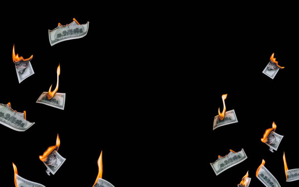 Several 100 dollar bills, falling down, burn on a black background. The concept of bankruptcy, default, depreciation, devaluation, wastefulness and waste of money. Copy space, isolated.