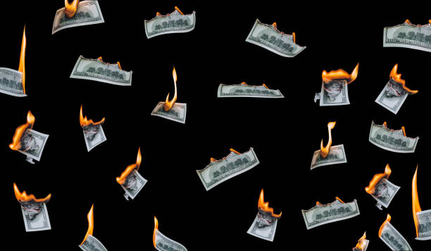 istock Several 100 dollar bills, falling down, burn on a black background. The concept of bankruptcy, depreciation, devaluation, wastefulness and waste of money. Isolated. 1316136570