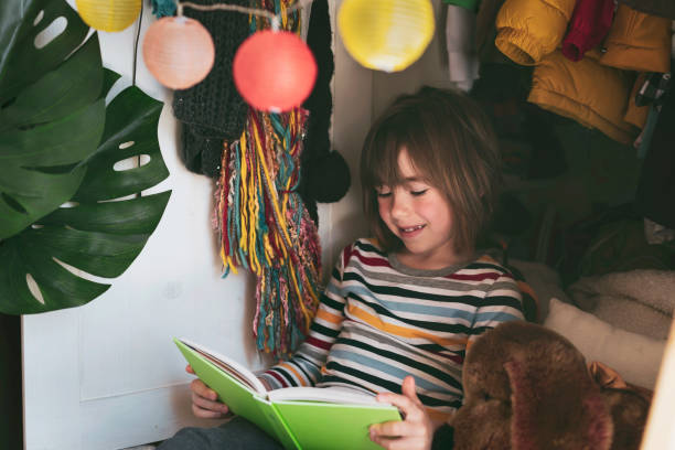 istock Cute child reading a book at home 1316143104