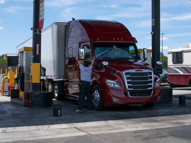 トラックの運転手は、トラックの停留所でトラックのタクシーのフロントガラスを打つ。 - truck driver truck trucking semi truck ストックフォトと画像