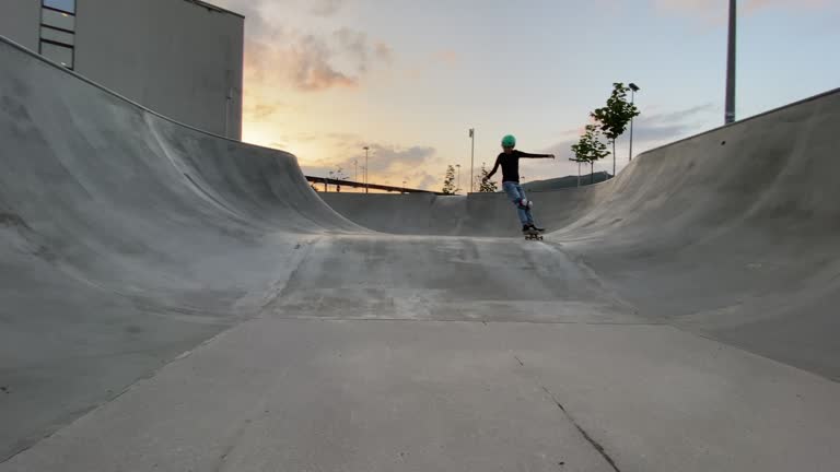 Little skateboarder dropping into the bowl