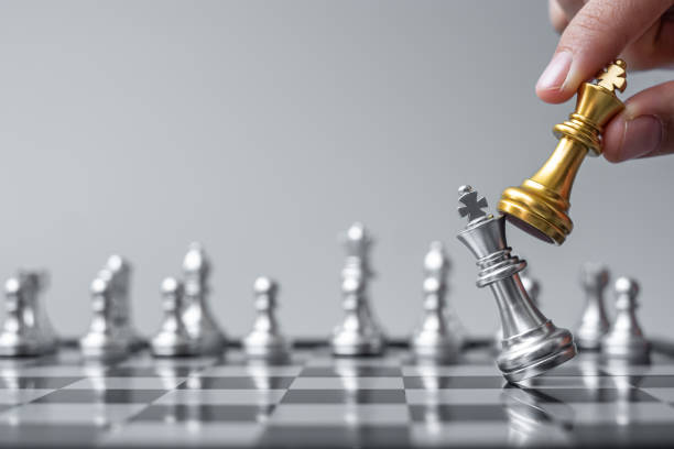 istock businessman hand moving gold Chess King figure and Checkmate opponent during chessboard competition. Strategy, Success, management, business planning, disruption and leadership concept 1316160865