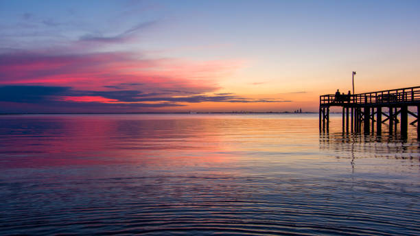 Pier at sunset Bayfront Pier on Mobile Bay at sunset in Daphne, Alabama mobile bay stock pictures, royalty-free photos & images