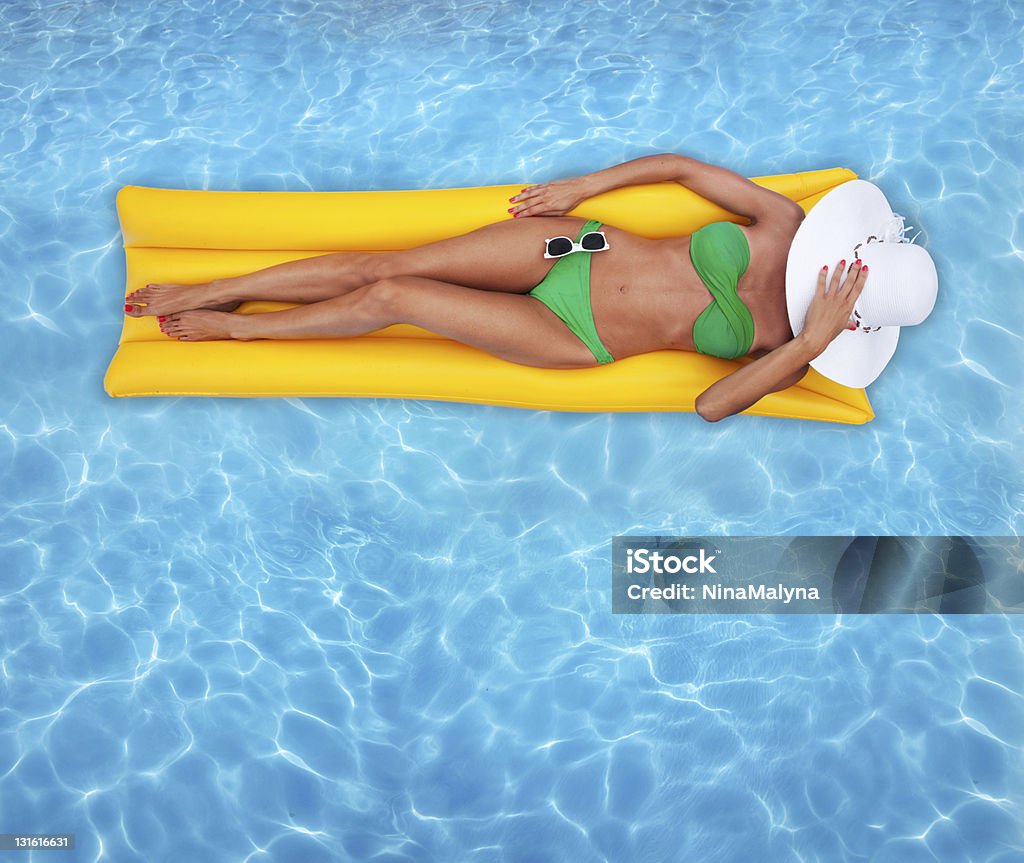 Mulher em Amarelo em um raft piscina - Foto de stock de Biquíni royalty-free