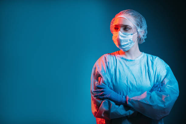 covid-19 outbreak pandemic banner pensive doctor Covid-19 outbreak. Pandemic banner. Respiratory infection risk. Portrait of disturbed pensive female doctor in ppe face mask goggles looking at copy space isolated on dark blue background. isolated on dark stock pictures, royalty-free photos & images