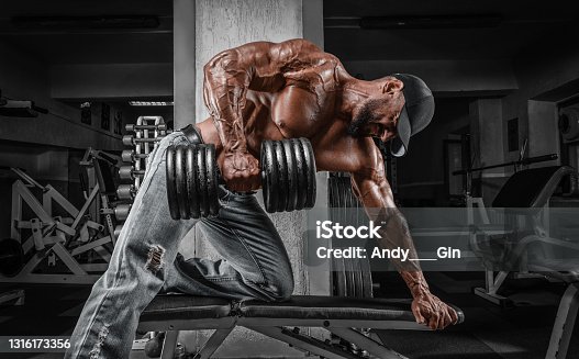 istock Muscular man pulls a dumbbell towards his stomach. Bodybuilding and powerlifting concept. 1316173356