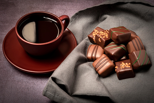 Assortment of fine chocolates with a cup of coffee.