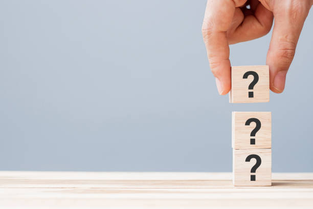 istock hand holding Questions Mark ( ? ) on wooden cube block on table background. FAQ( frequency asked questions), Answer, Q and A, Information, Communication and interrogation Concepts 1316179138