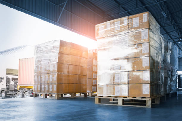 impilato di scatole di imballaggio che si caricano nel camion container. carico parcheggiato camion al magazzino della banchina. servizio di consegna. logistica del magazzino di spedizione. trasporto camion merci spedizione. - deposito foto e immagini stock