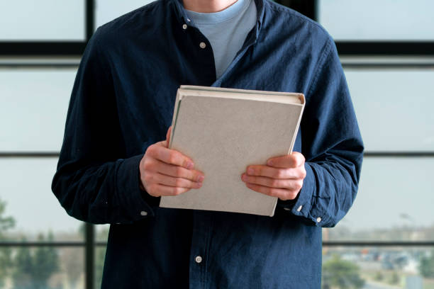 istock person holding and giving a book, share a present and knowledge 1316181792