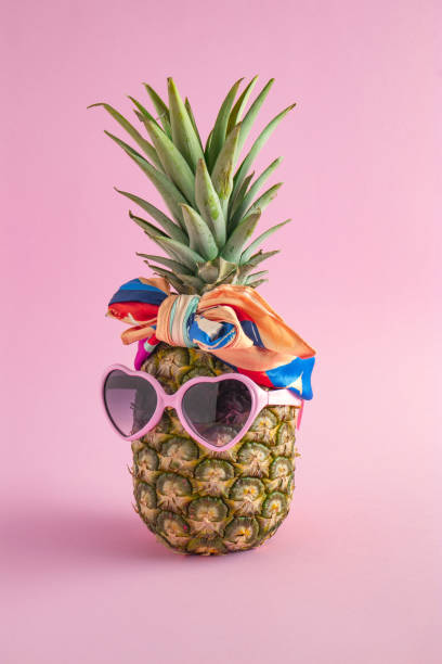 Creative summer idea with Pineapple hipster in sunglasses and scarf, stylish fruit. Minimal tropical concept. Art fashionable vacation concept. Summertime color mood, pineapple fruit