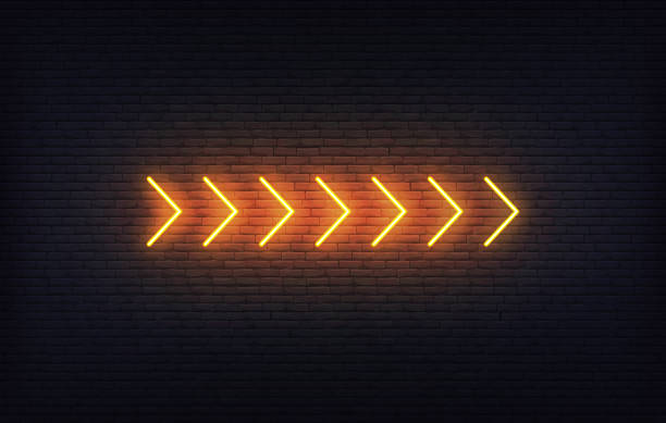 istock Neon arrow sign. Set of orange glowing neon arrow pointer on brick wall background. 1316192802