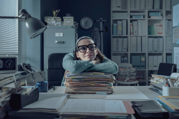 istock Inefficient office worker leaning on a pile of paperwork 1316193909