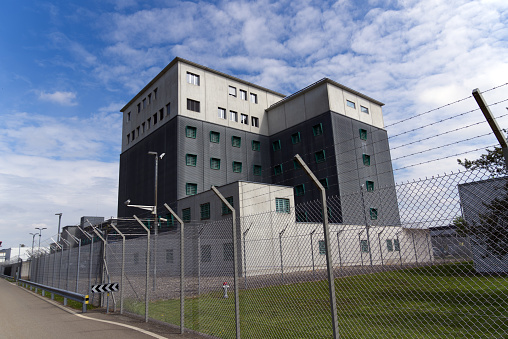 Prison buildings at Zurich airport with barbed wire fence in the foreground. Photo taken April 30th, 2021, Kloten, Switzerland.