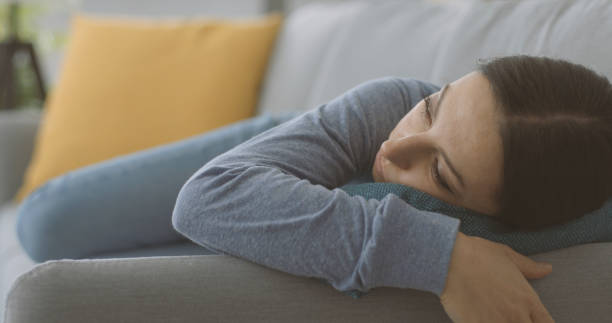 istock Depressed young woman lying down on the couch 1316199279