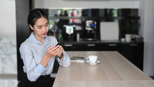 istock Young asian woman employee using mobile phone during coffee break in office. 1316199397