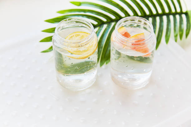 Handmade summer drinks with tropical flowers. Hard seltzer with lemon and grapefruit. Homemade summer cocktails concept on white background Handmade summer drinks with tropical flowers. Hard seltzer with lemon and grapefruit. Homemade summer cocktails concept on white background. High quality photo soda water glass lemon stock pictures, royalty-free photos & images