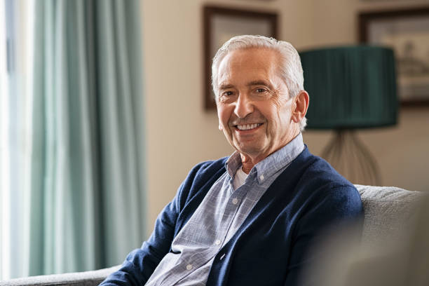 istock Happy senior man sitting at home 1316201831