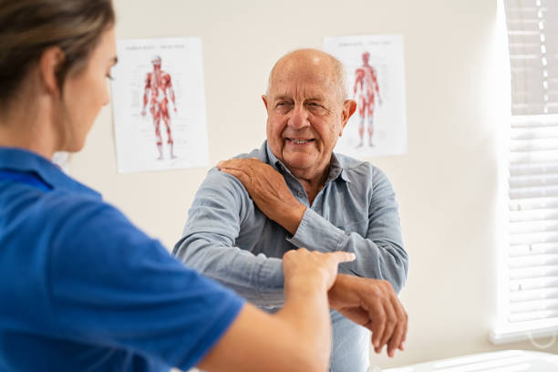 Physiotherapist working with senior patient in clinic Young woman physiotherapist helping senior man with elbow exercise in clinic. Young woman doctor checking elbow of senior patient. Old man during an appointment with professional osteopath in private clinic working and massaging his shoulder pain. shoulder stock pictures, royalty-free photos & images