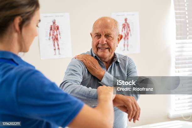 Physiotherapist Working With Senior Patient In Clinic Stock Photo - Download Image Now