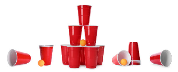 beer pong. ensemble avec les tasses et les boules en plastique rouges sur le fond blanc, conception de bannière - disposable cup red beer plastic photos et images de collection