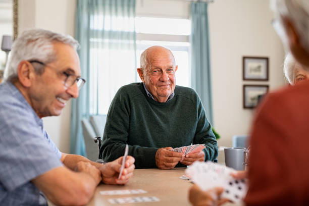 istock Senior joyful friends playing cards together 1316203848
