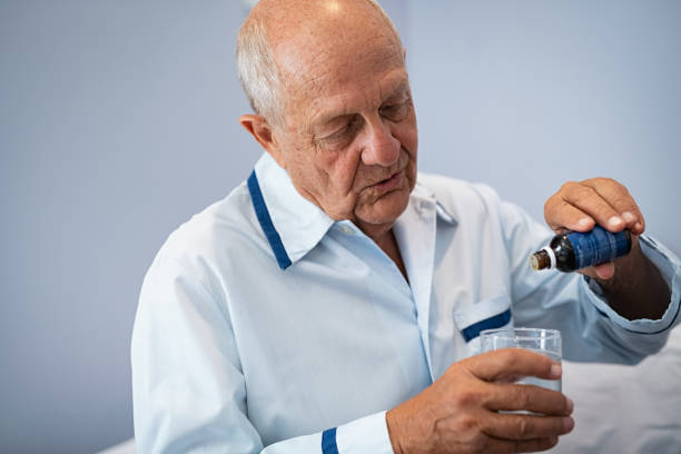 senior patient taking medicine drops for sleep - narcotic medicine pill insomnia imagens e fotografias de stock