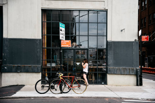 New York City, USA - June 20, 2018: People walking on street in Dumbo (Brooklyn) in front of storefront of restaurant with bicycles parked.