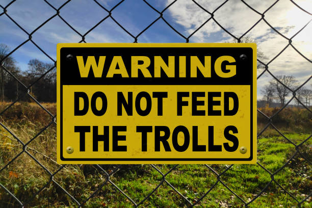 Warning - Do not feed the trolls Black and yellow warning sign on a fence stating in "Warning - Do not feed the trolls". internet trolling stock pictures, royalty-free photos & images