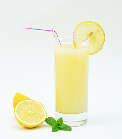 Lemonade, lemon, mint, and straw on white background, refreshing, nutritious and healthy drink
