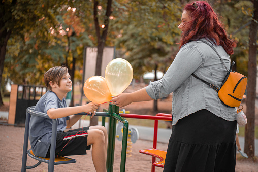 Big sister rotate her brother on a carousel