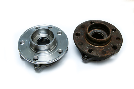The comparison of the new shiny and old rusty and broken car wheel bearings isolated on a white background.