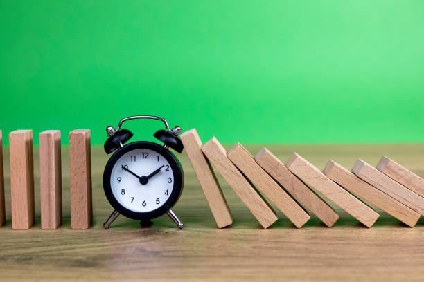 istock domino effect concept with wooden tiles blocked by clock 1316210683