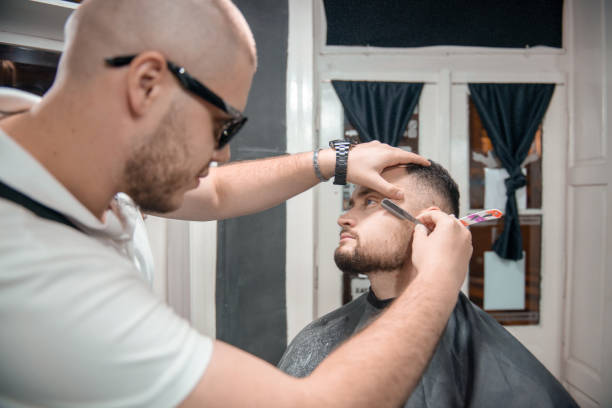 istock Barber is cutting and making shape of customers beard 1316210990